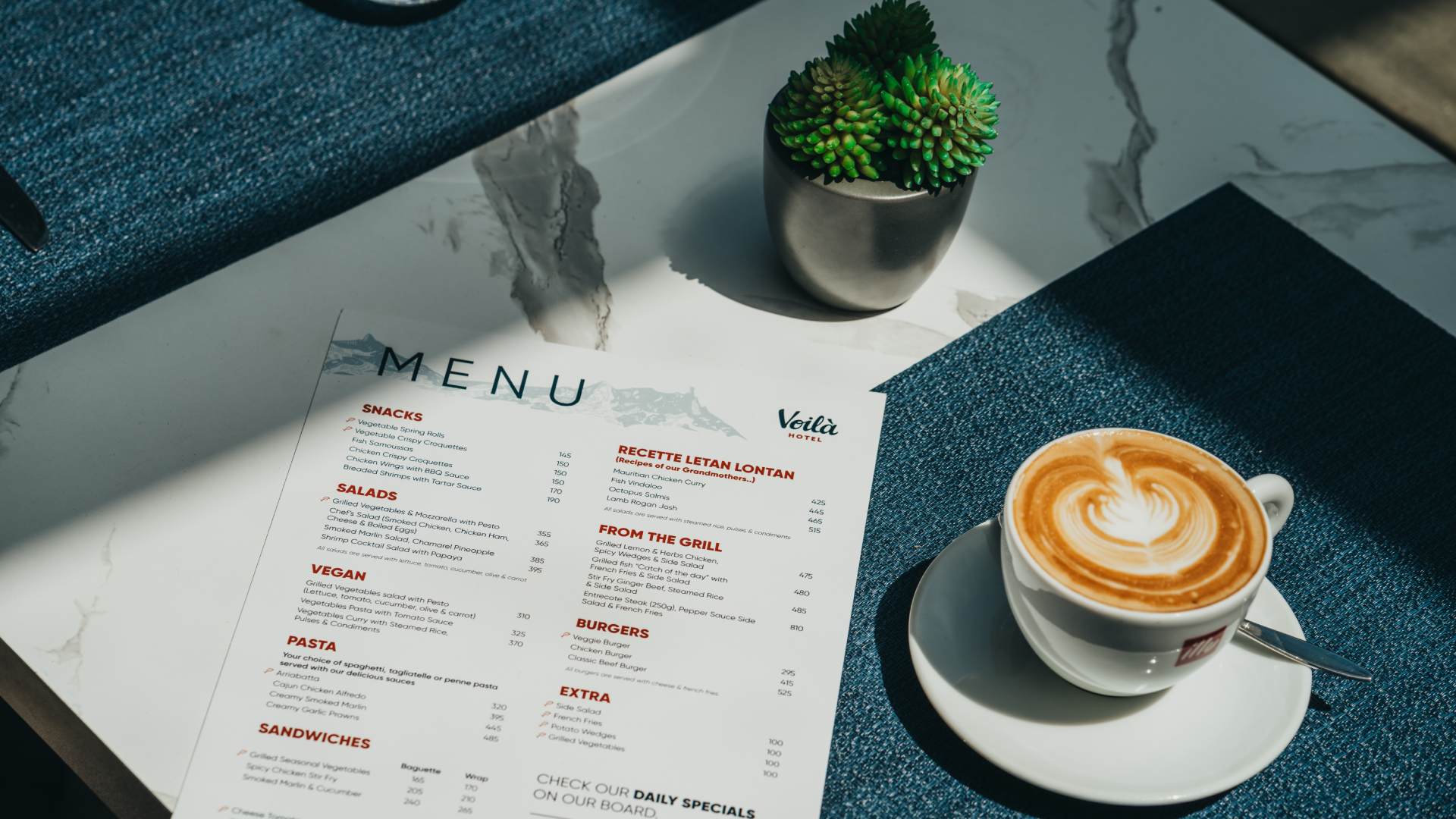 Guests browsing the restaurant menu at Voilà Hotel in Mauritius